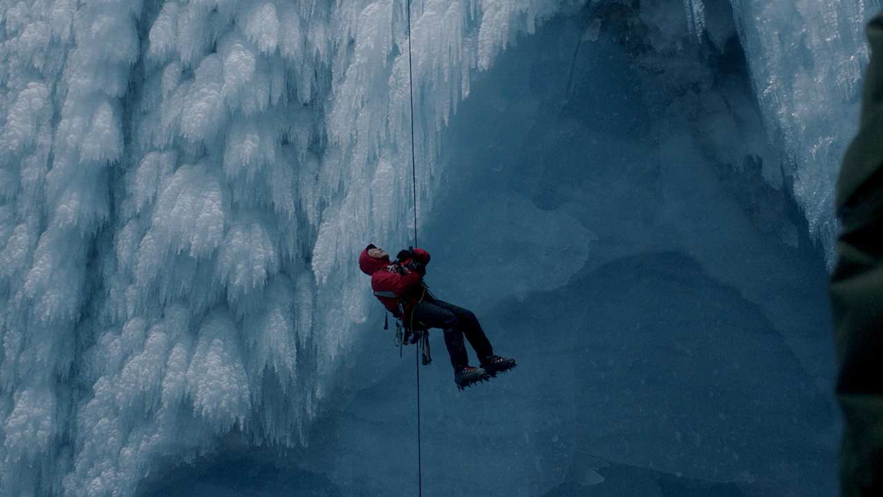 a person being suspended from a rope amidst ice